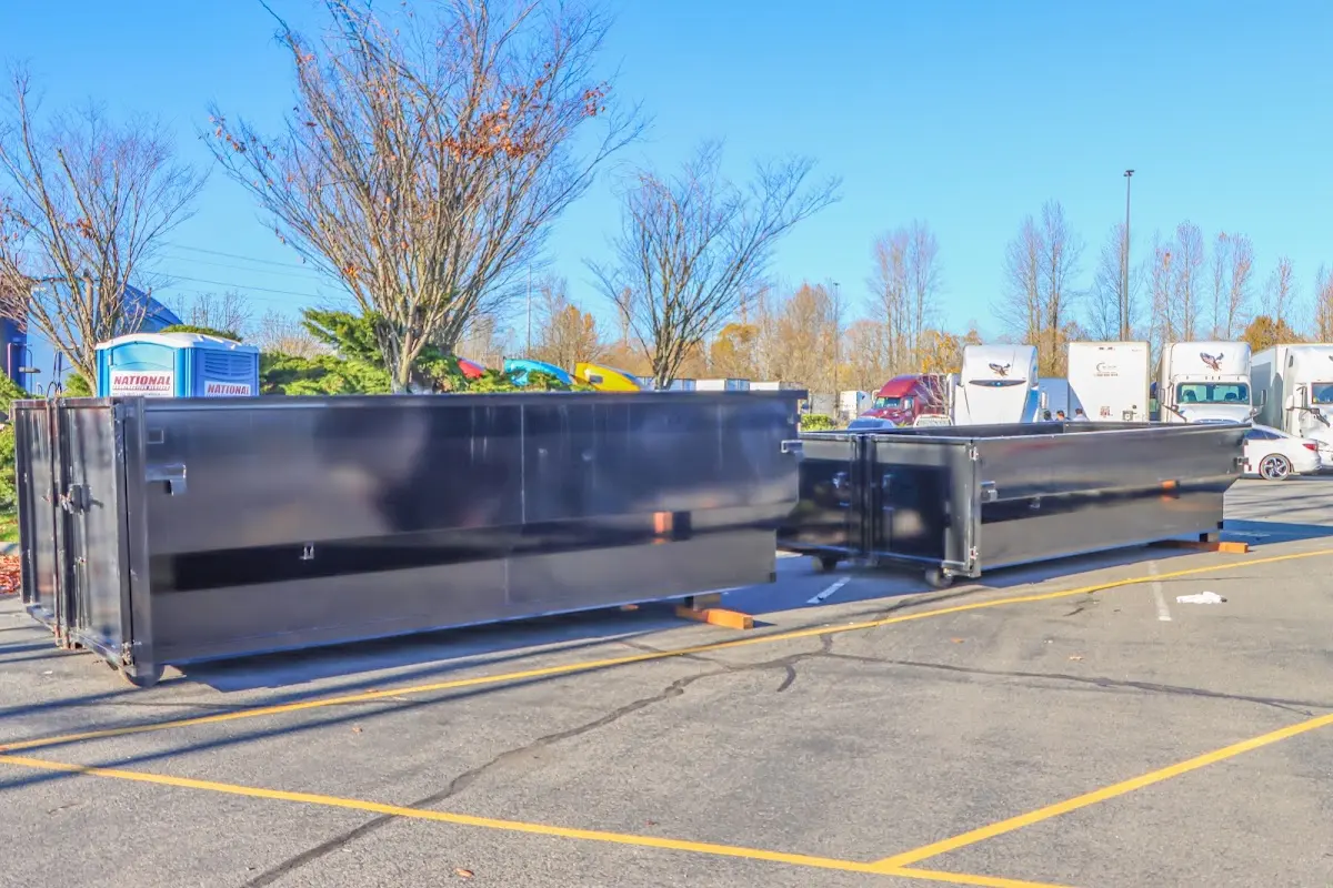 Professional dumpster rental service with roll-off container on residential driveway in The Meadows